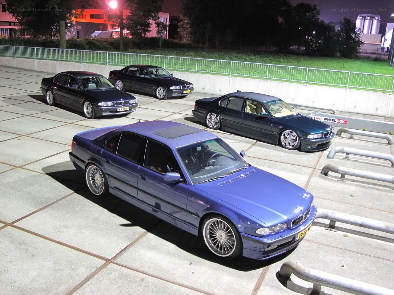 Four BMW sedans at night