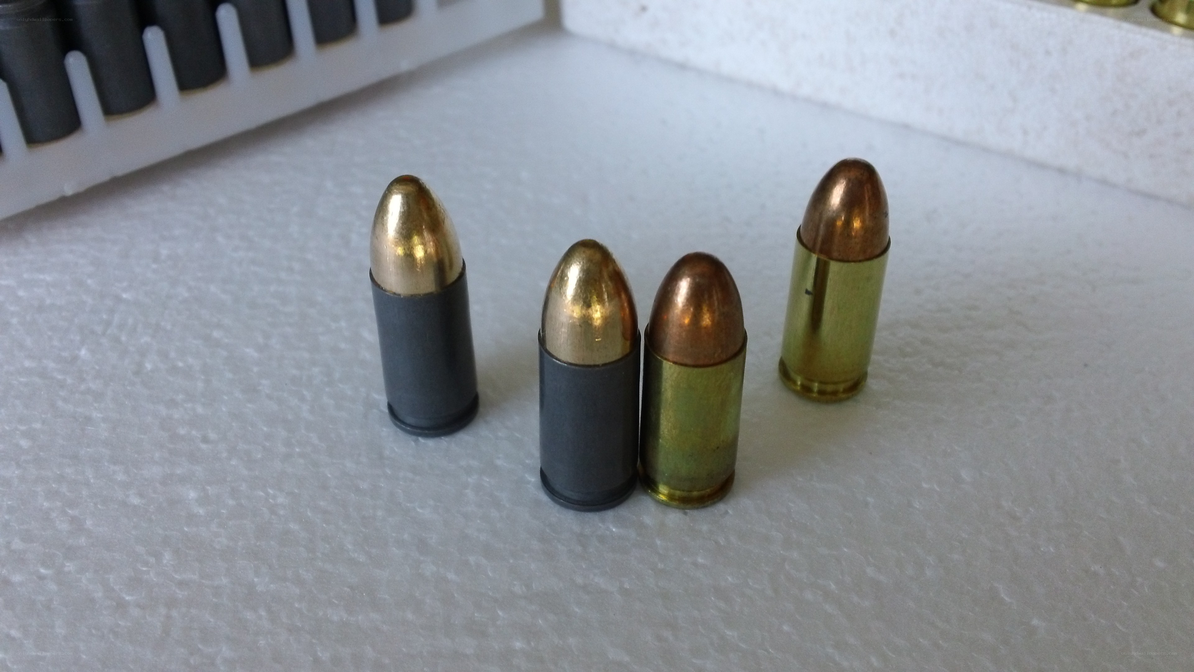 Four bullets on white surface