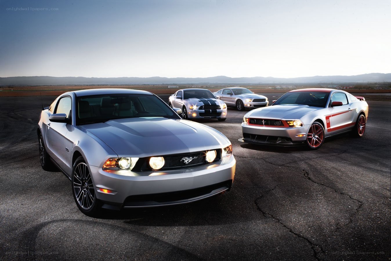 Four Ford Mustangs on a racetrack