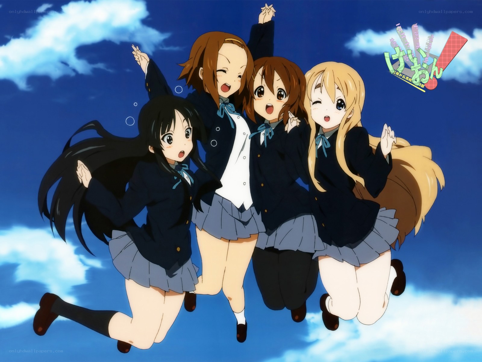 Four girls in school uniforms jumping