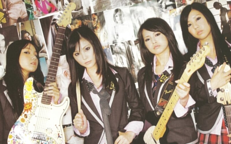 four girls with guitars in school uniforms