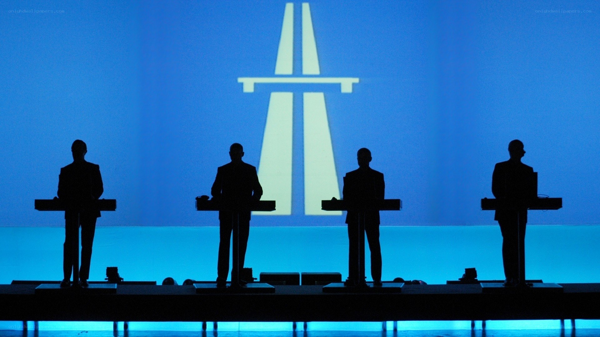 Four men at podiums on stage