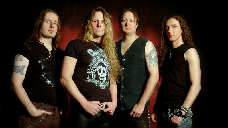Four Men in Band Attire — Black, Serious, Photograph, Tattoos, Long Hair