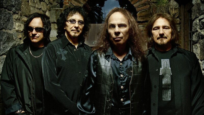 Four Men in Black Clothing — Serious, Photograph, Stone Wall