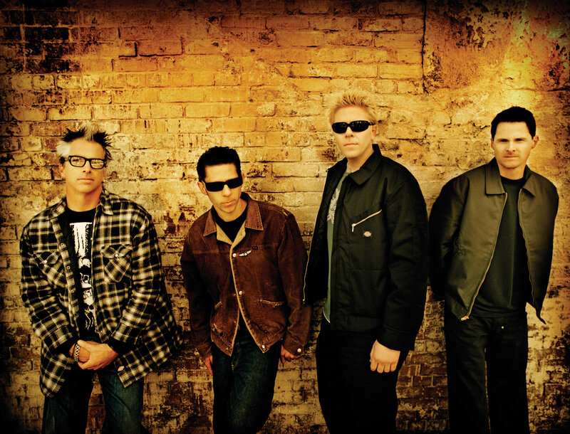Four Men in Front of Brick Wall — Brown, Serious