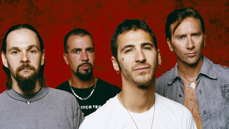 Four Men in Front of Red Wall