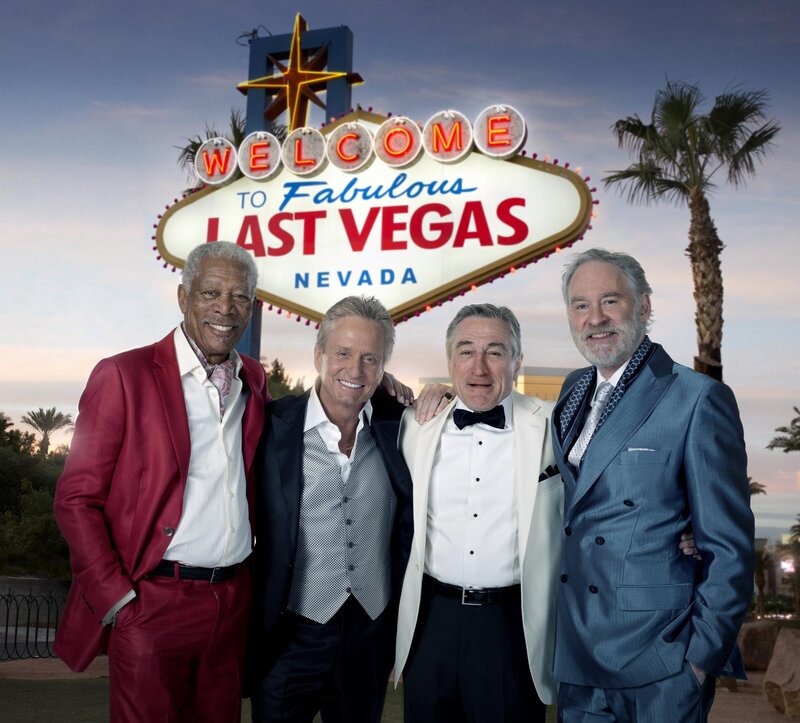 Four men in suits at Las Vegas sign