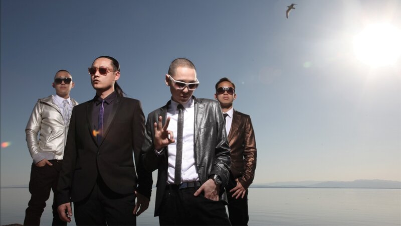 four men in suits by the water