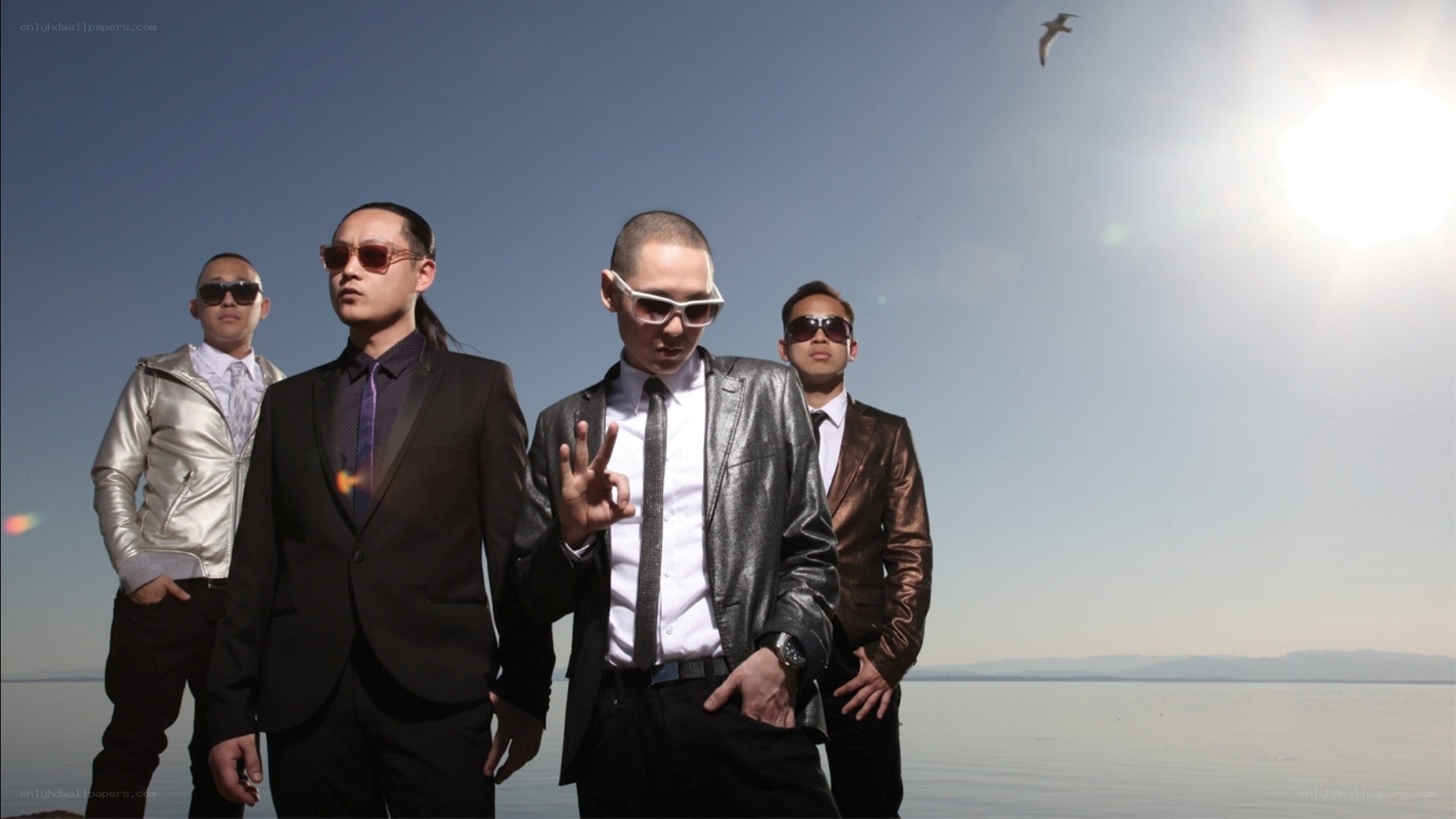 four men in suits by the water