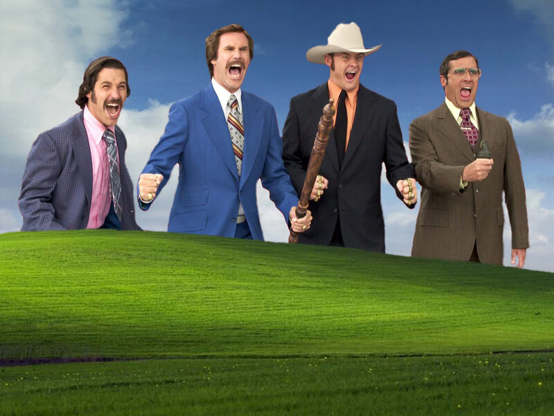 Four men in suits on a green hill