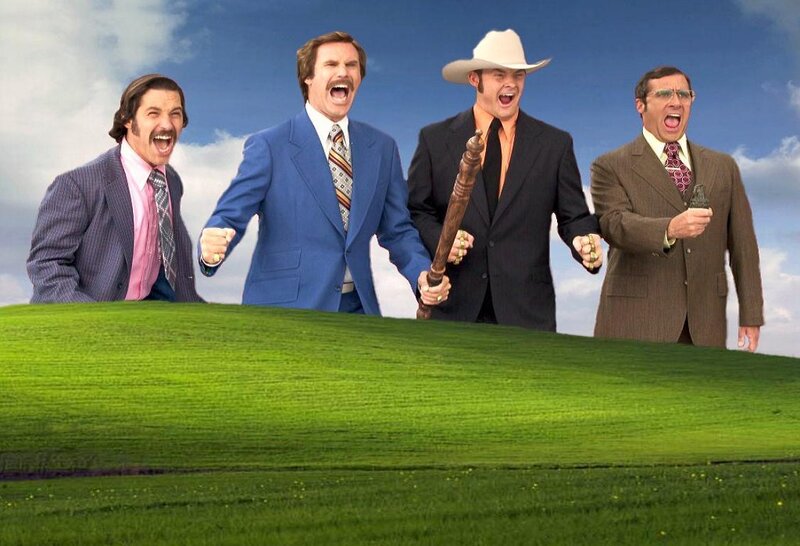 Four men in suits on a green hill