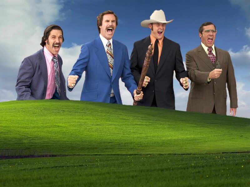 Four men in suits on a green hill