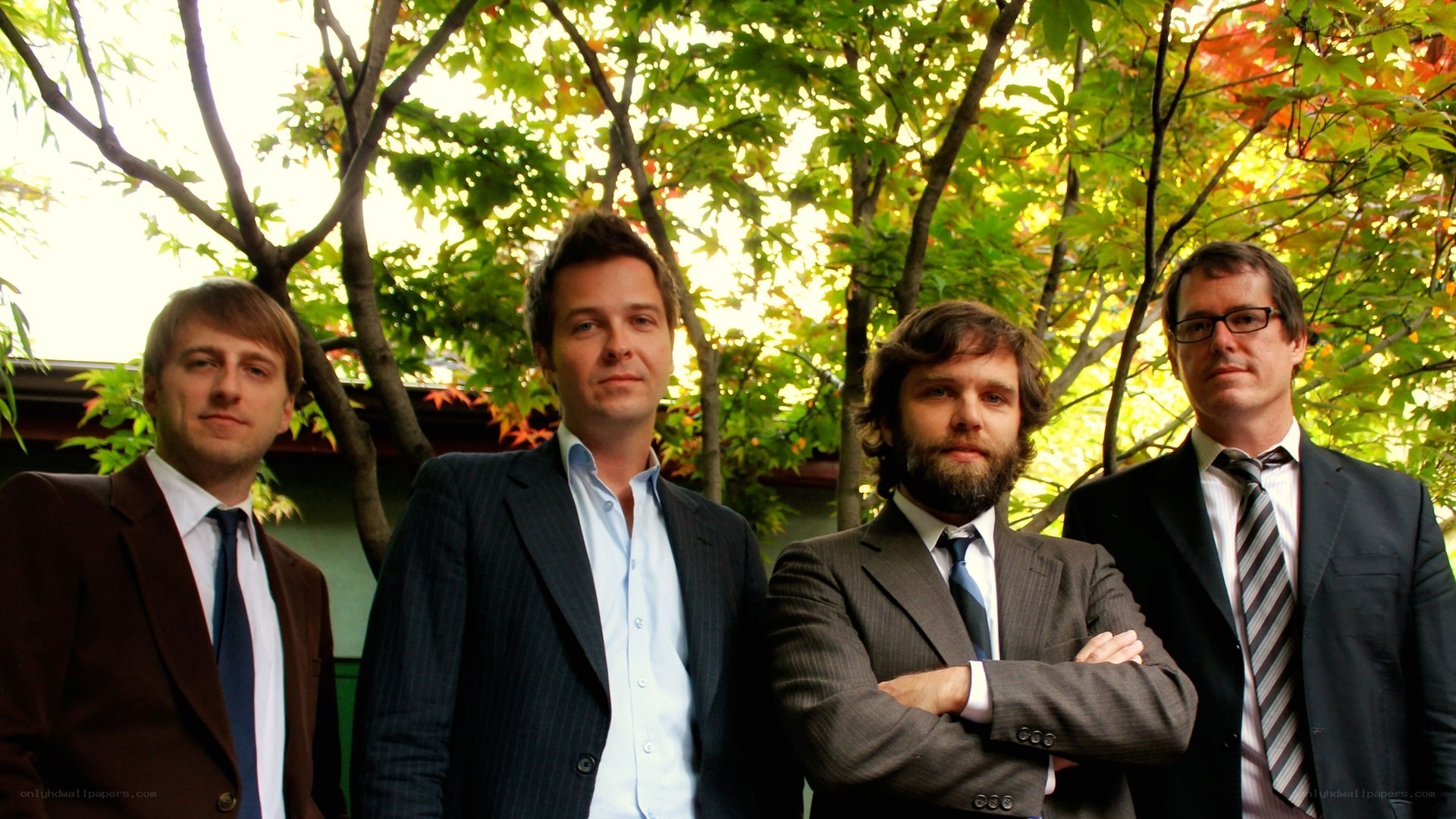 four men in suits outdoors