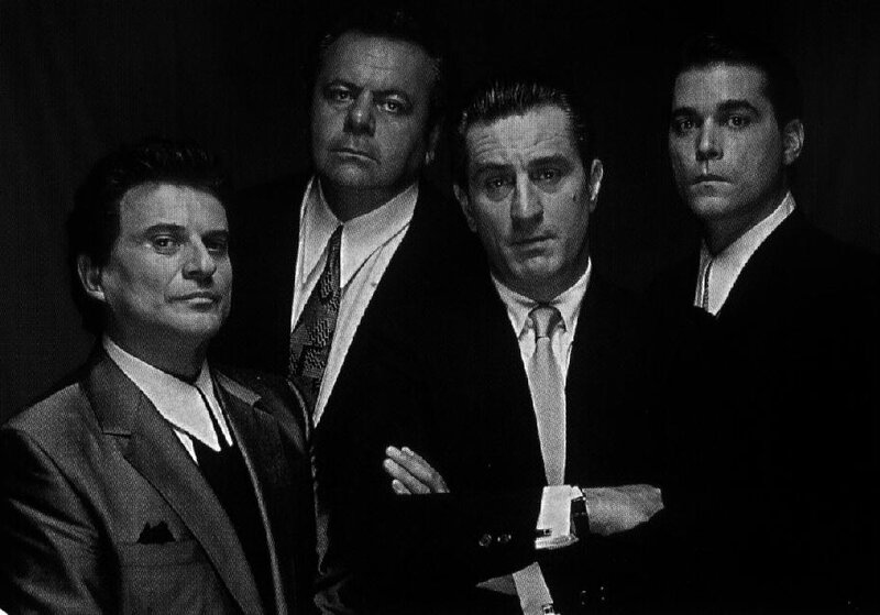 Four men in suits pose for a photo
