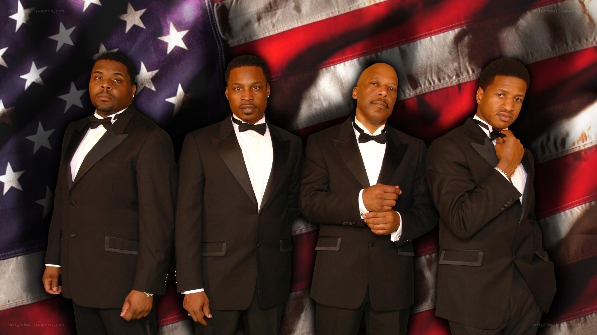 Four men in tuxedos with American flag