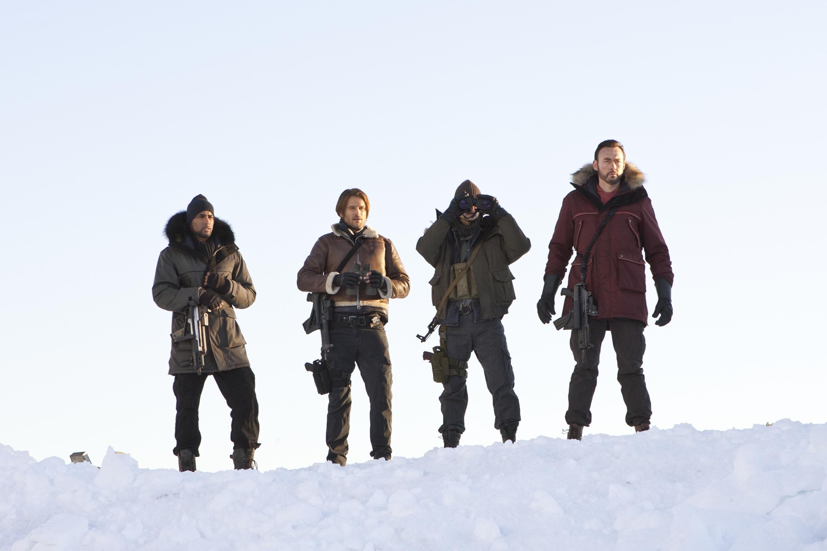 Four men in winter gear with weapons