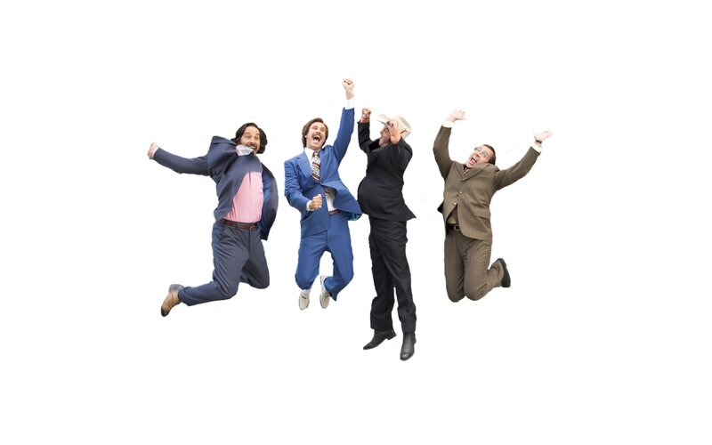 four men jumping in suits