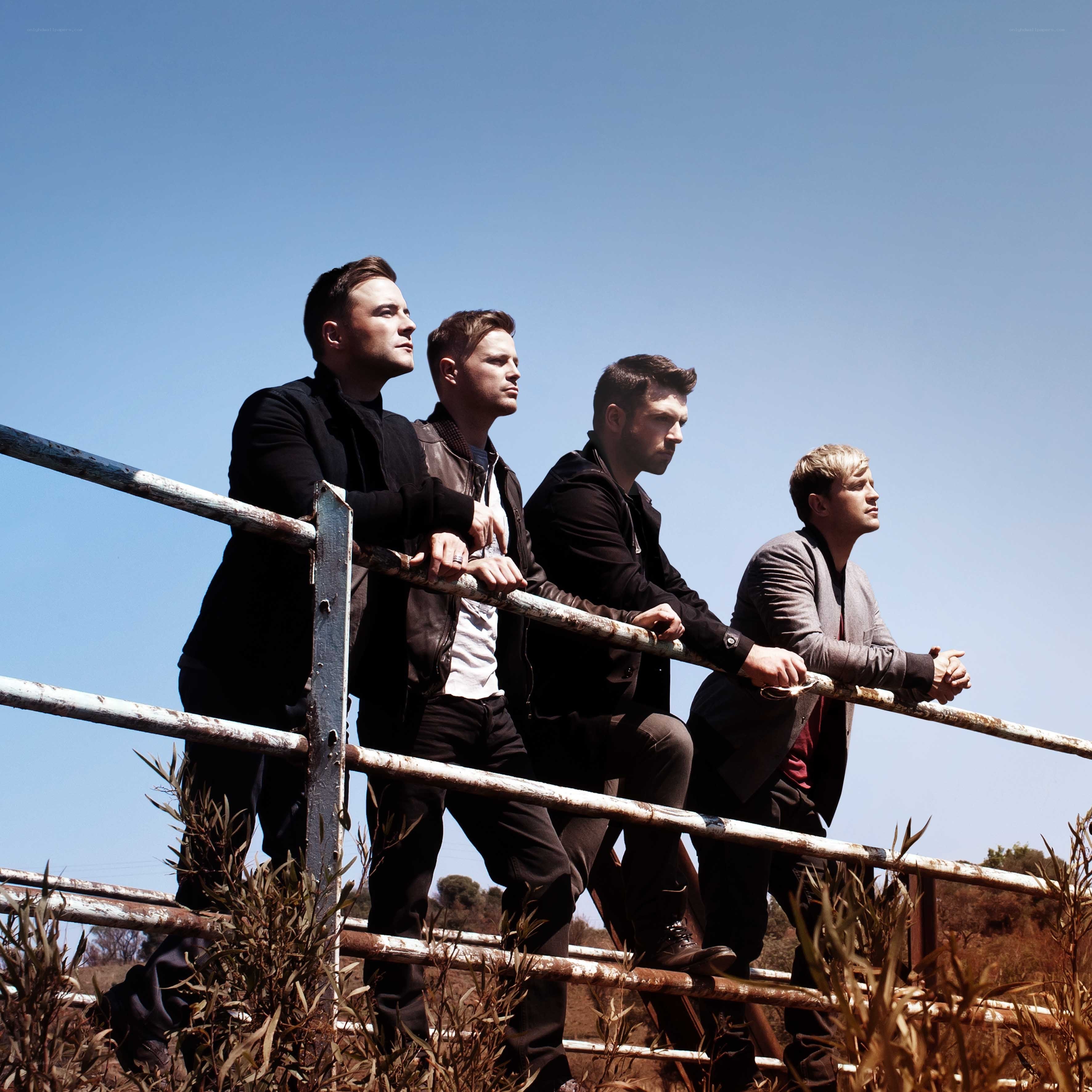 four men on a fence