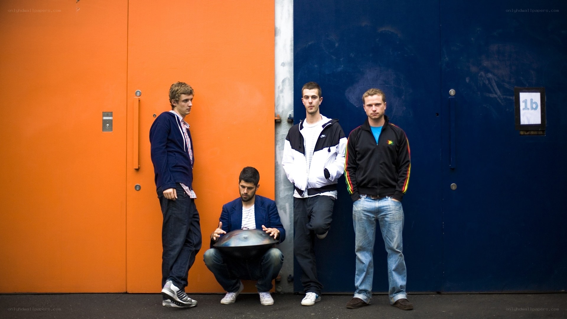 Four men posing by colorful doors
