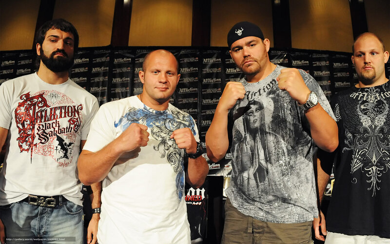 Four men posing in front of Affliction backdrop