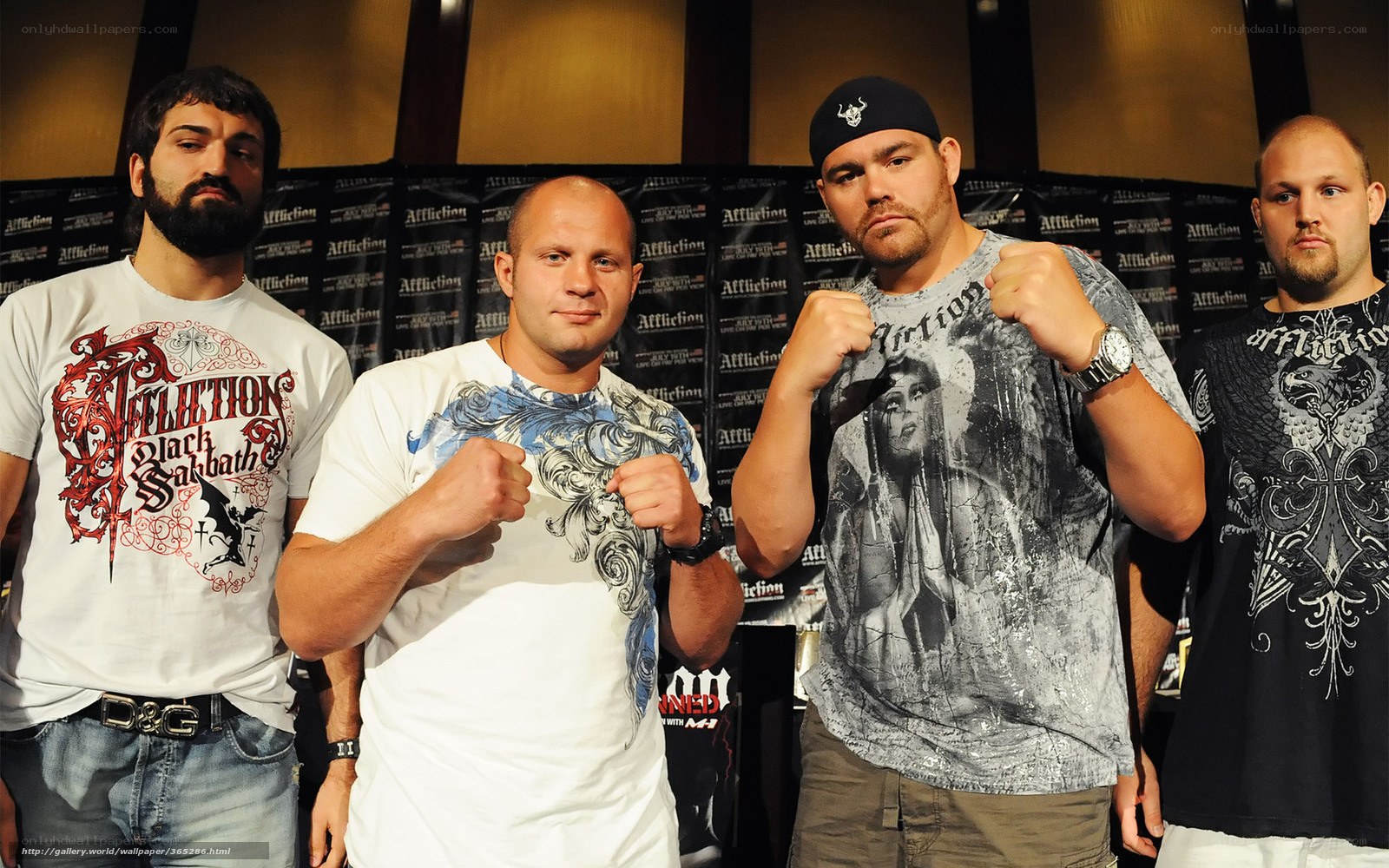 Four men posing in front of Affliction backdrop