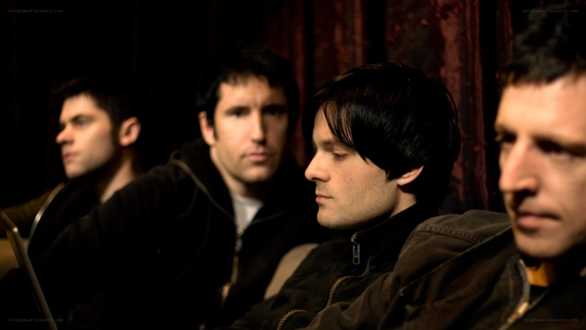 four men sitting in a row