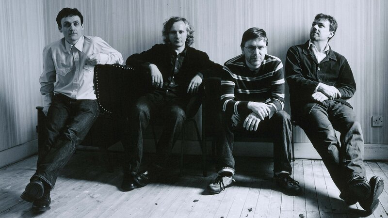 four men sitting on a bench