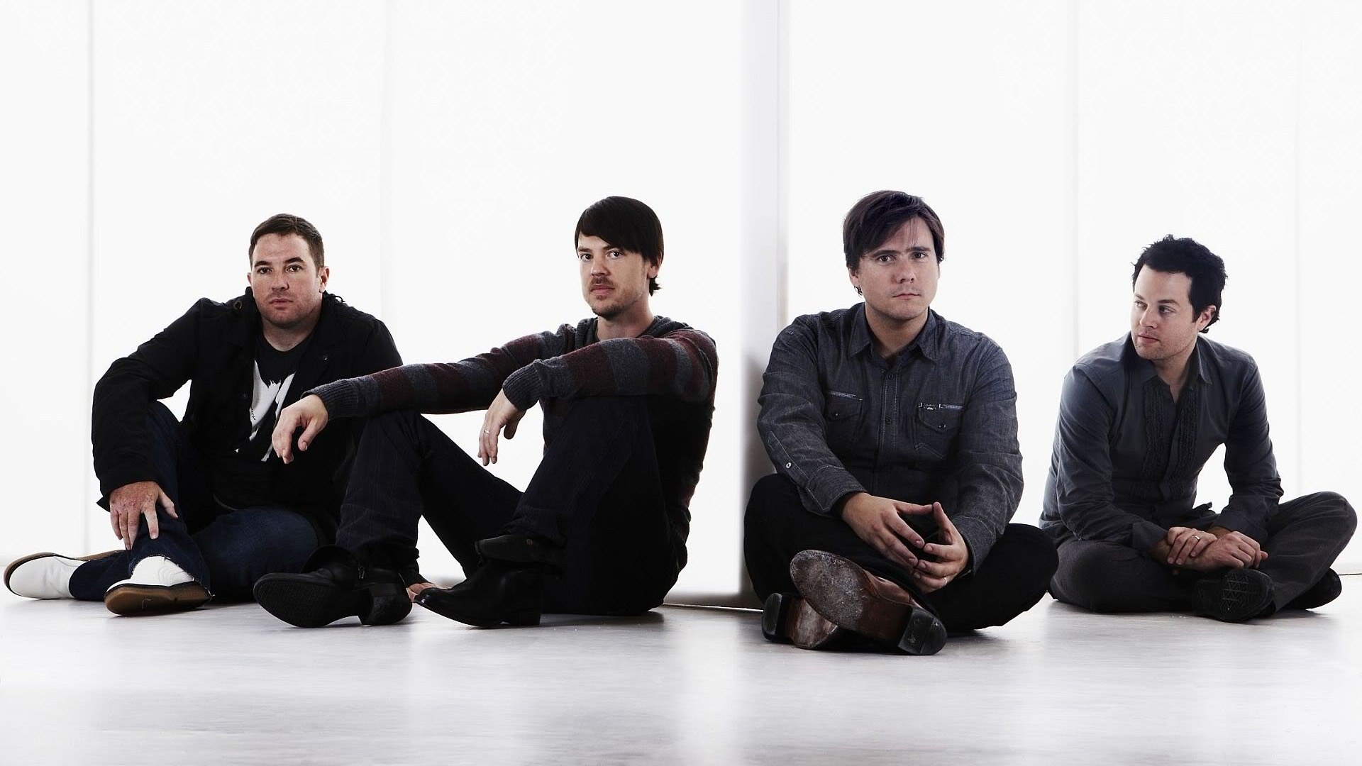four men sitting on floor