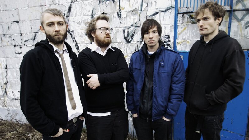 Four Men Standing — Black, Neutral, Photograph, Wall, Graffiti