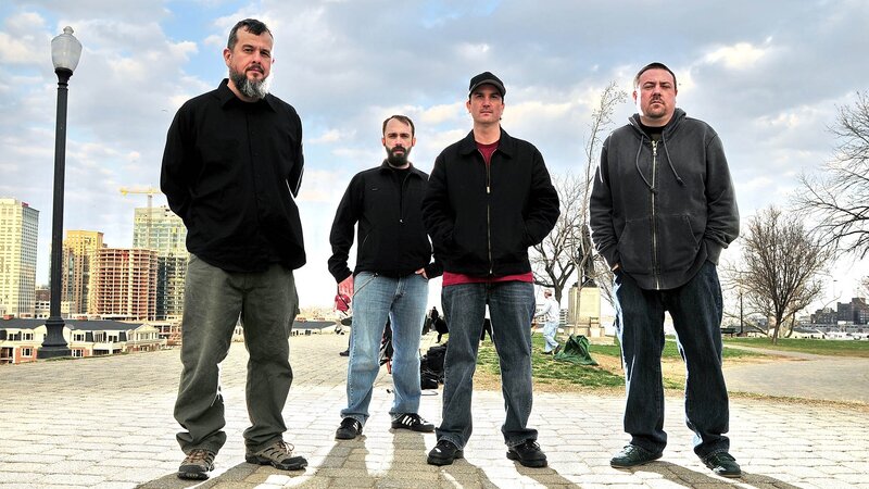 four men standing in a park