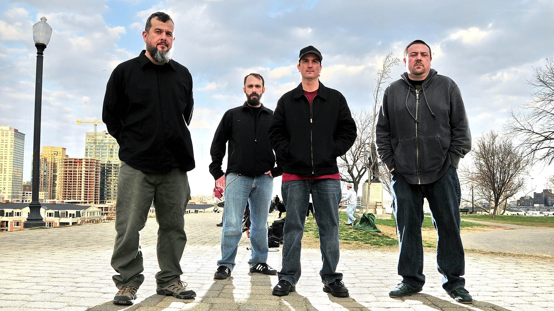 four men standing in a park