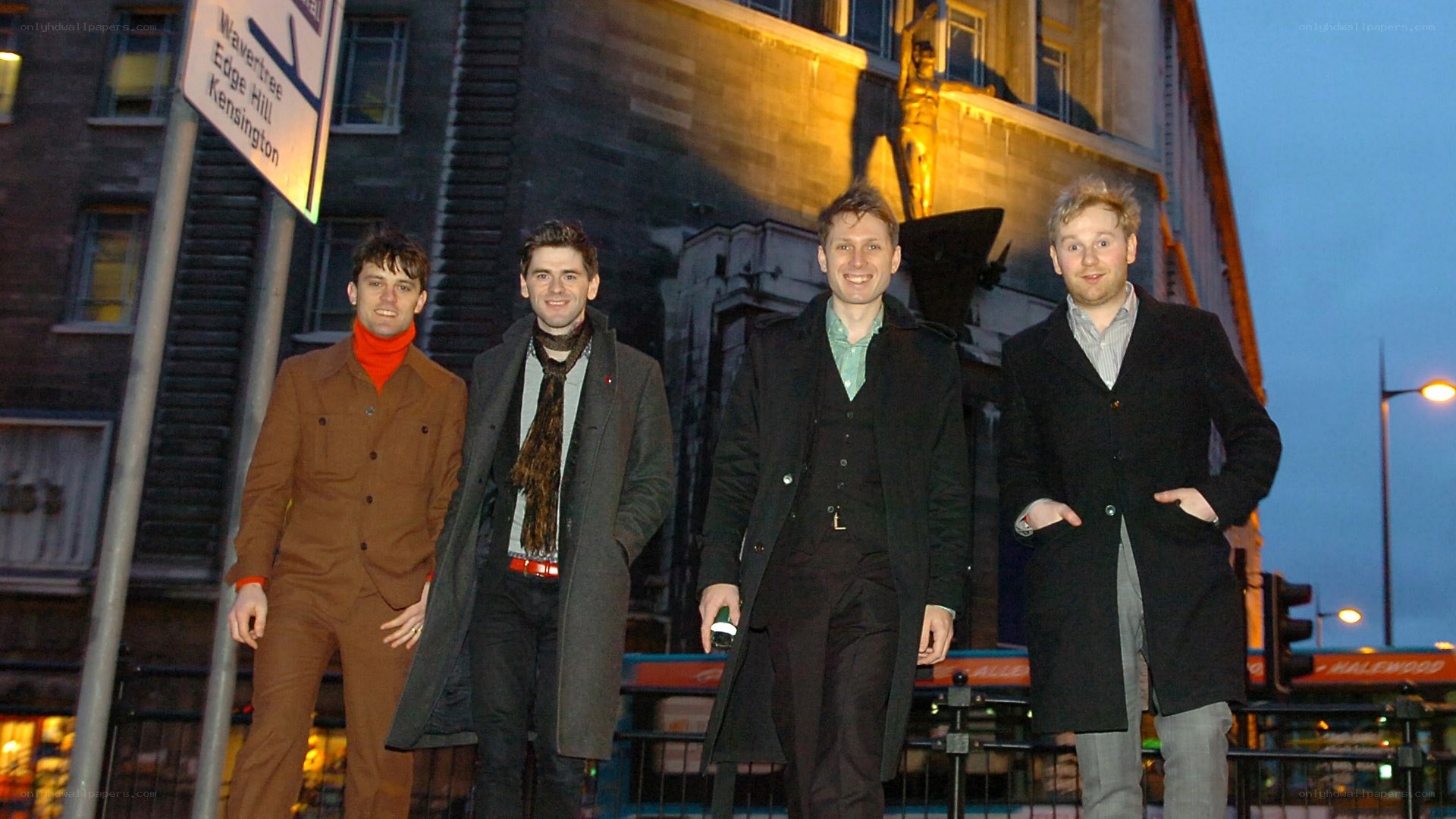 four men standing on a city street