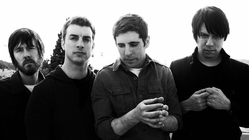 Four Men Standing Together — Black, Serious, Photograph, Trees