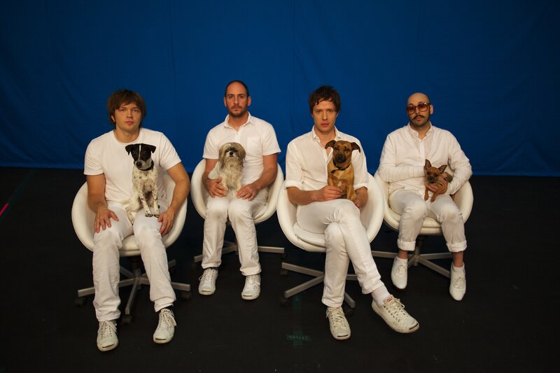 Four men with dogs in white