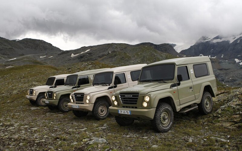 Four military-style vehicles in mountains