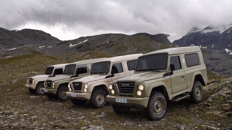 Four military-style vehicles in mountains