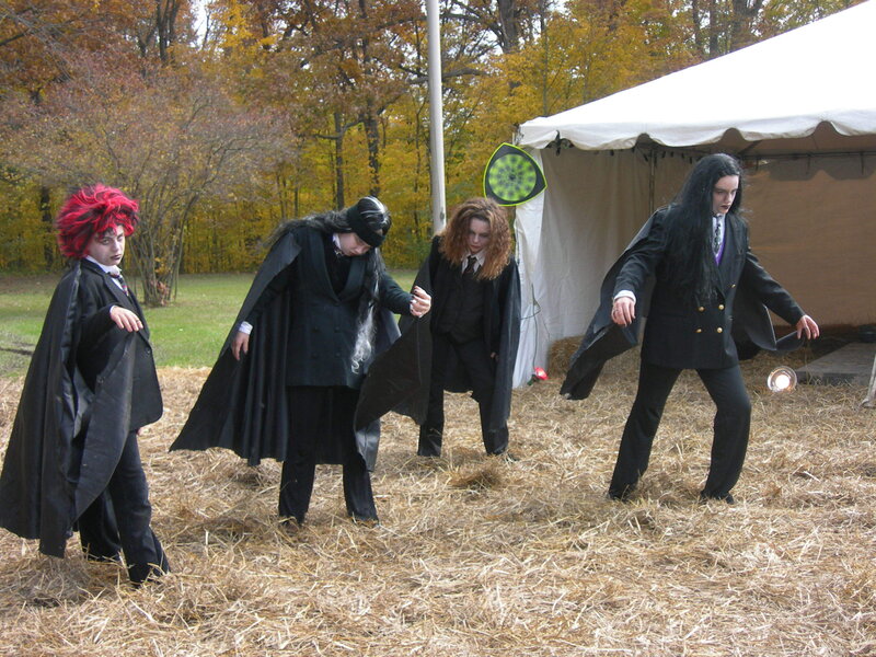 Four people in black costumes