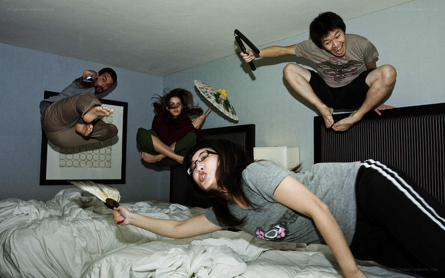 Four people in dynamic poses on a bed