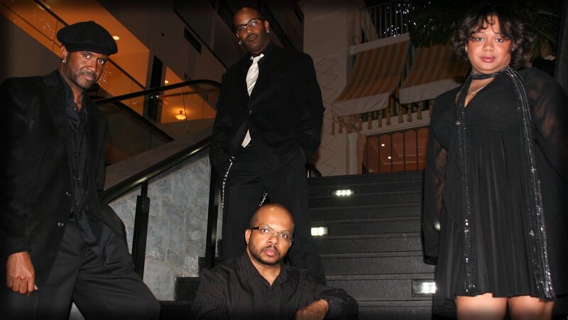 four people in formal wear on stairs