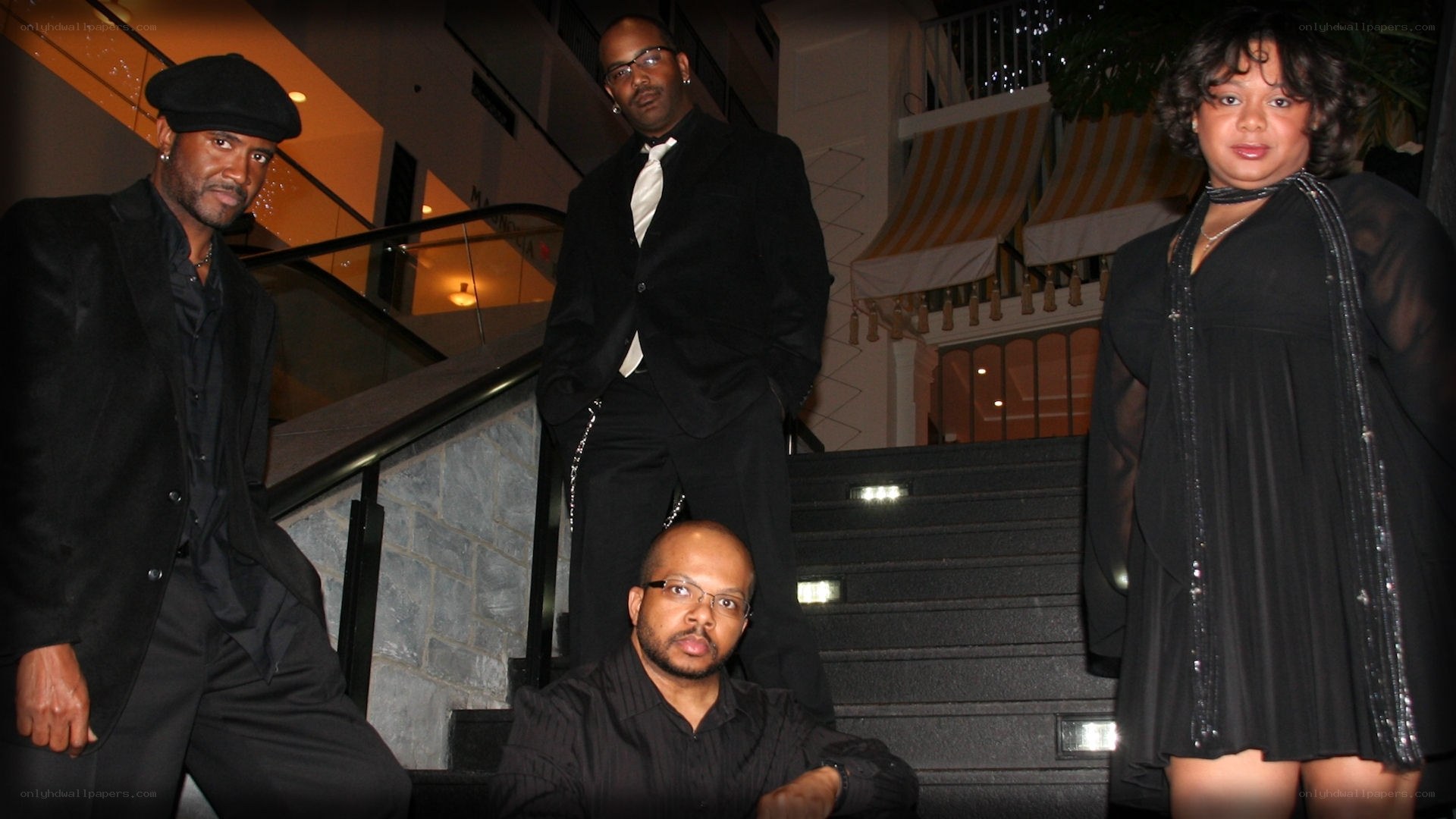 four people in formal wear on stairs