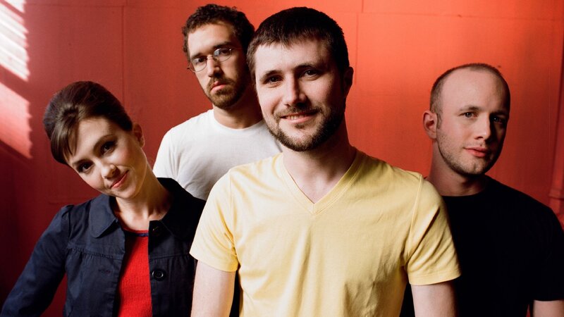 Four People in Front of Red Wall