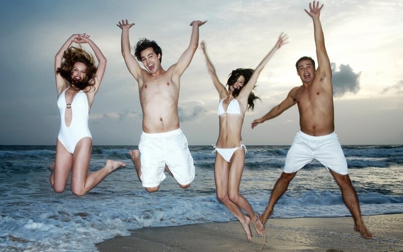 Four People Jumping on Beach