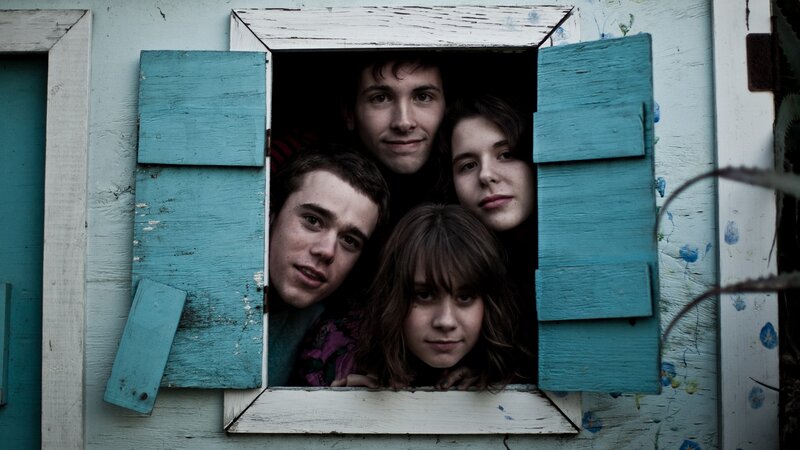four people looking out a window