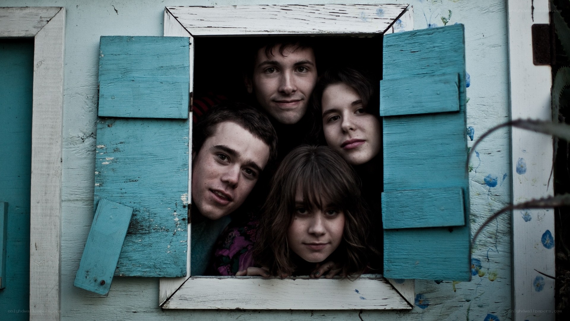 four people looking out a window