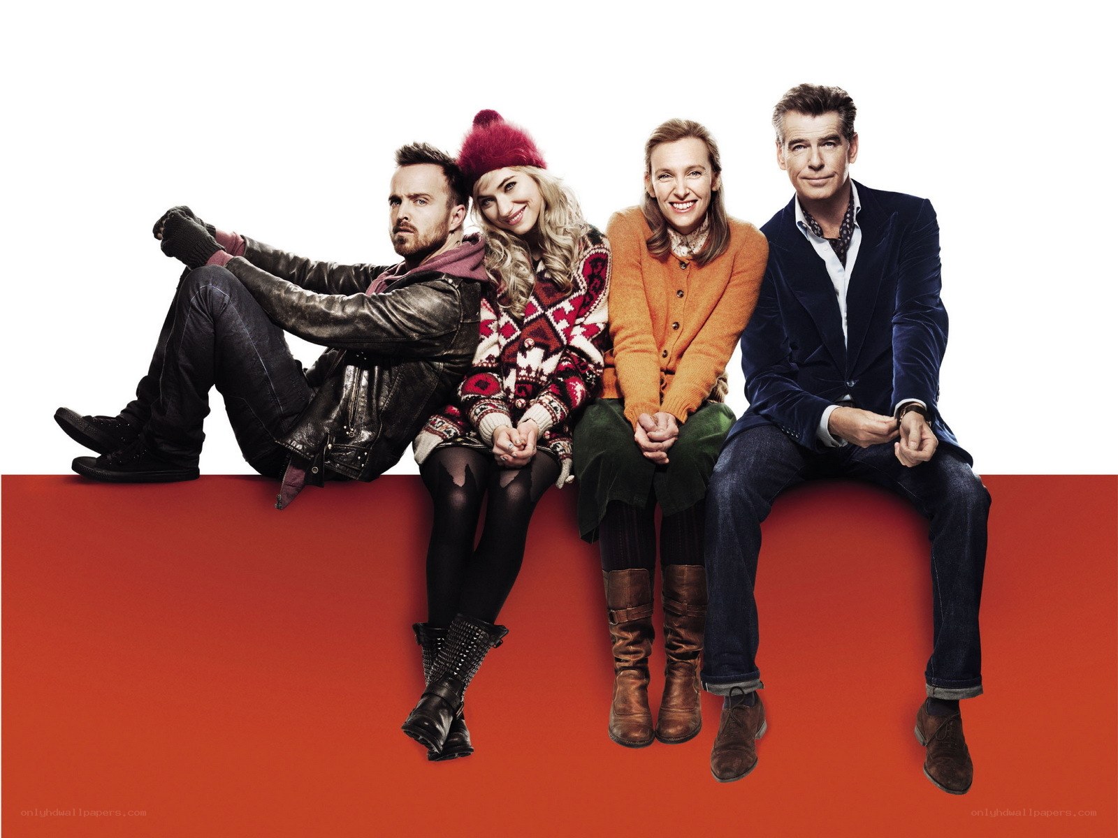 Four people sitting on a red surface