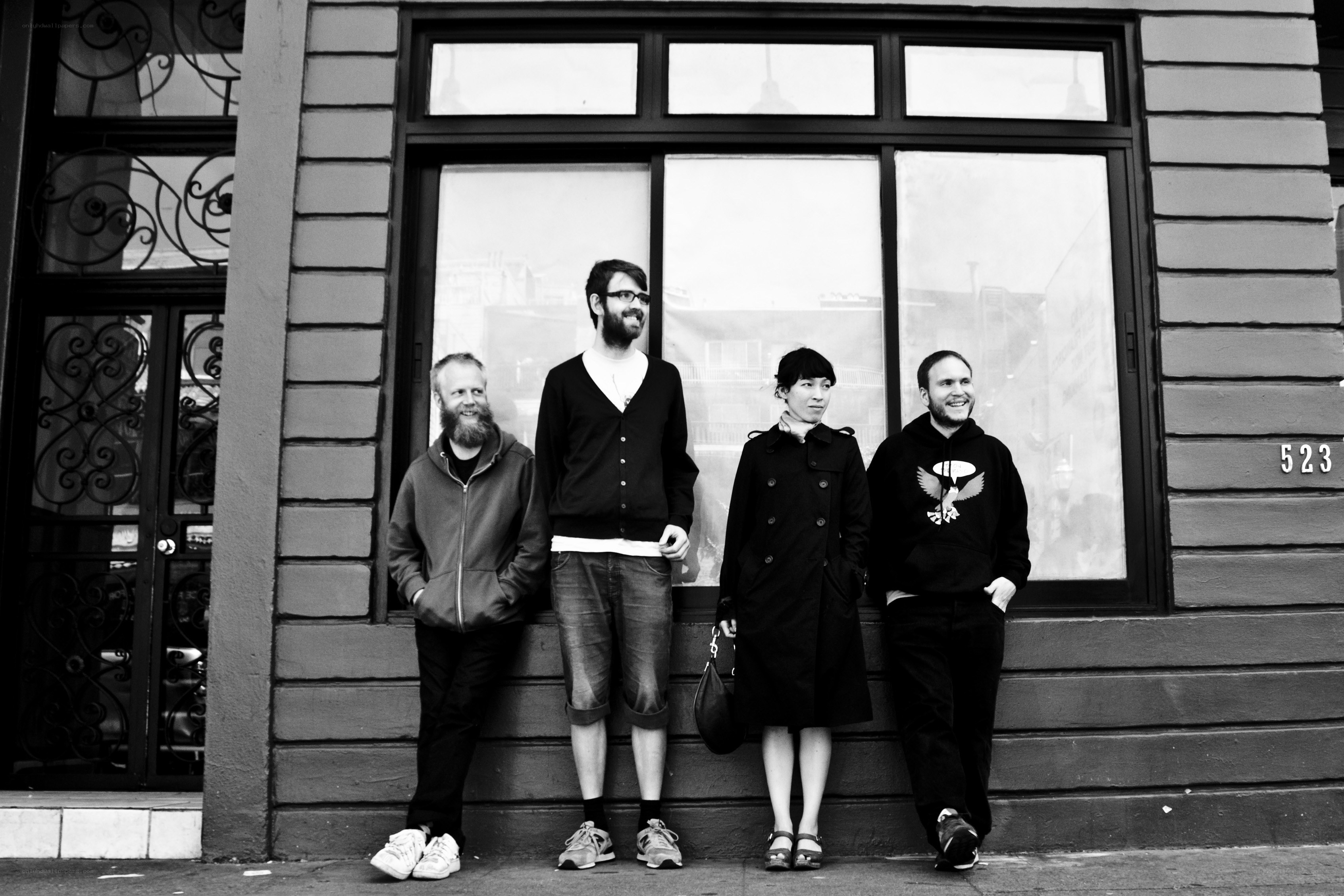four people standing outside a building