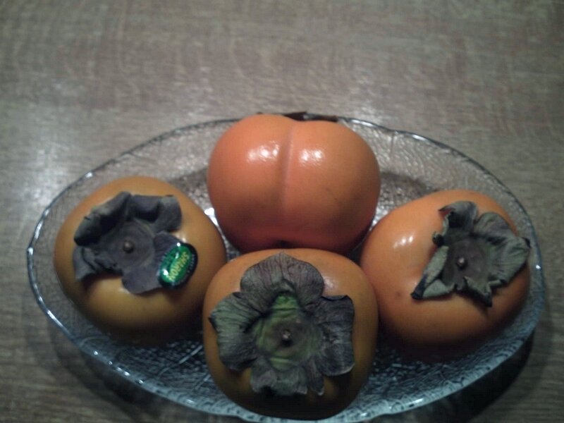 Four persimmons on a plate