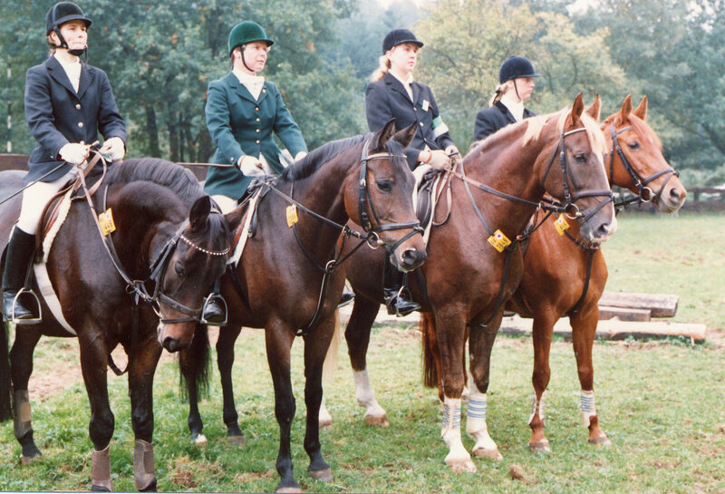 Four riders on horses at an event