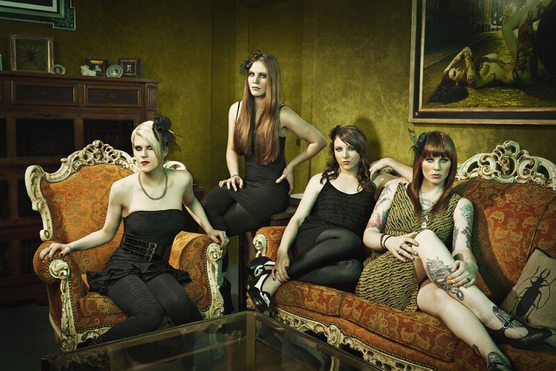 four women on ornate couch