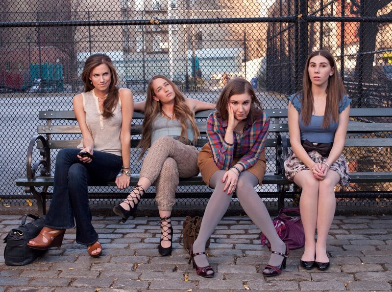 four women sitting on a park bench